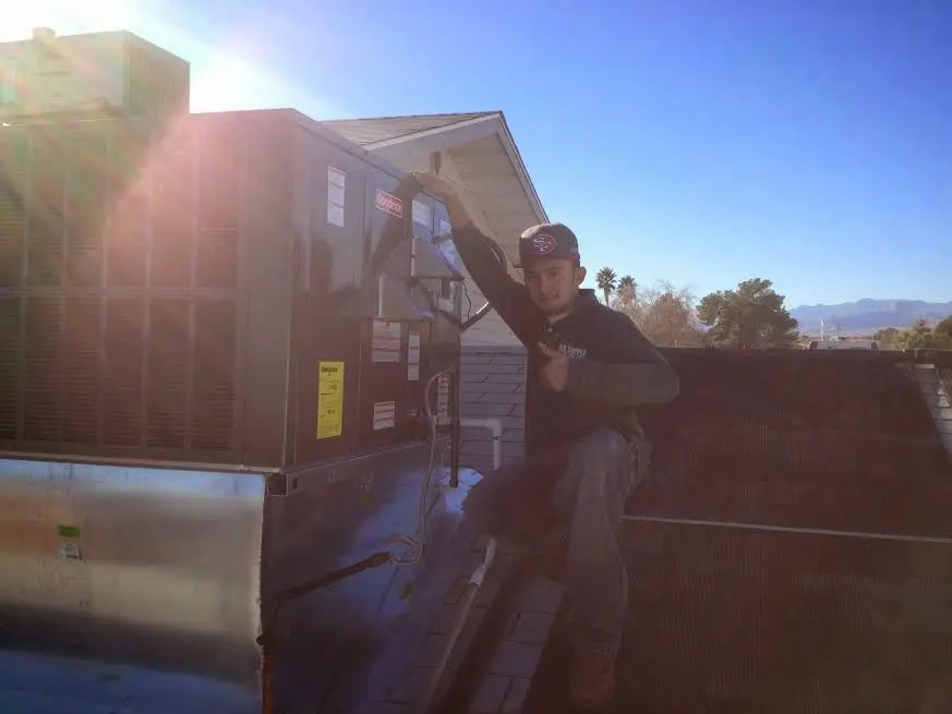 HVAC technician performing AC Tune-Up on a rooftop unit in Port Orchard